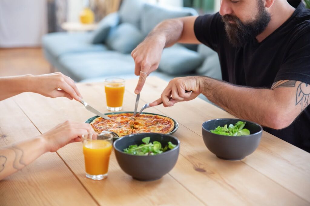 An image showing two people sharing food.