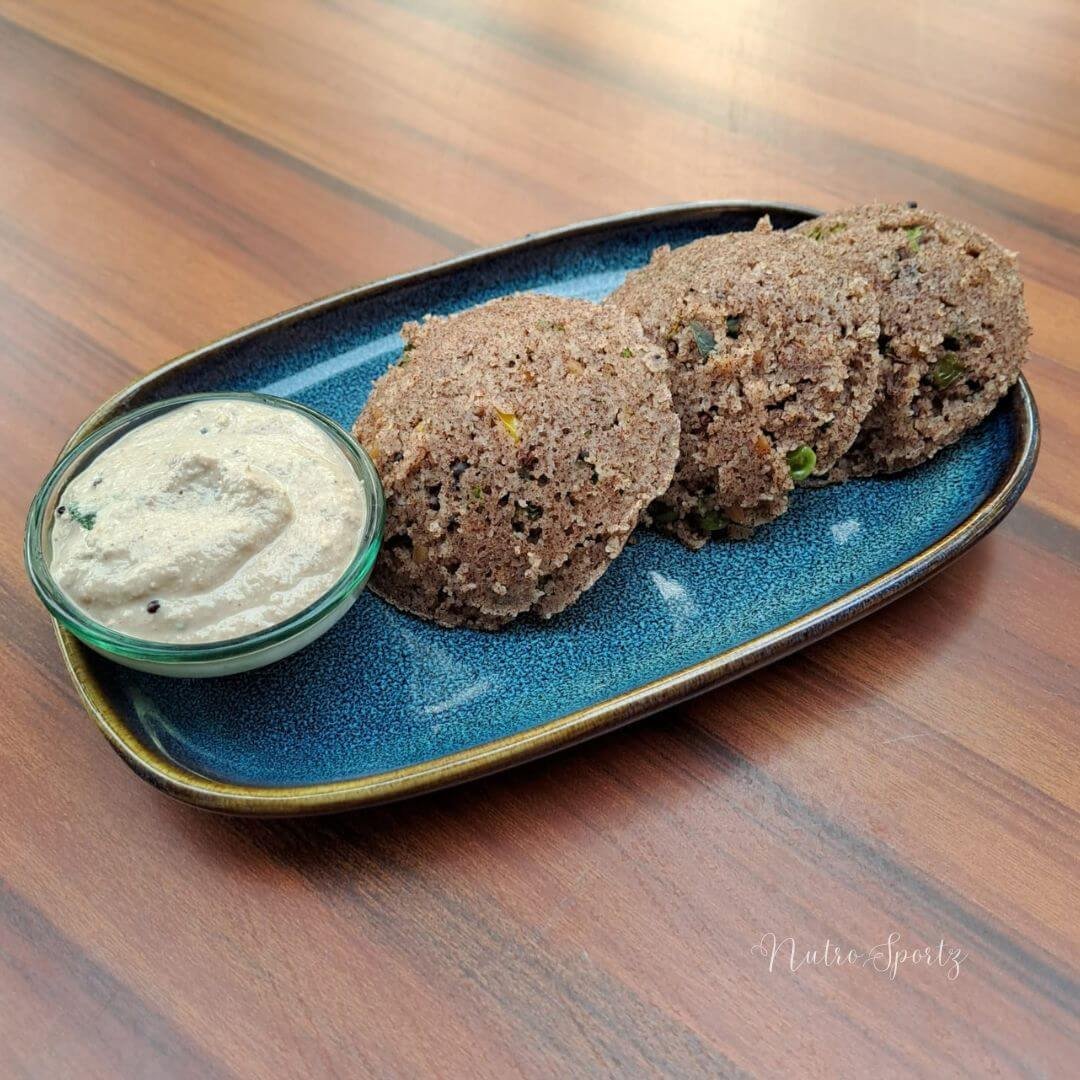 An image of instant ragi idli on a plate with peanut chutney.